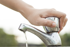 Image of person turning off faucet