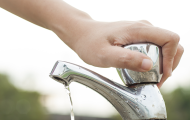 Image of person turning off water faucet