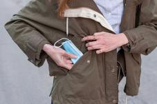 Woman with face covering in pocket