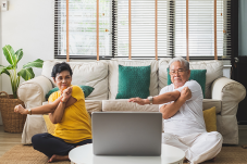 Two elderly people exercising at home