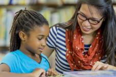 Image of young girl getting tutored by adult 