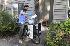 Young man delivering masks by bicycle