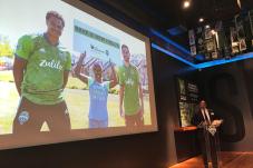Man at podium surrounded by Sounder soccer paraphernalia