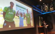 Man at podium surrounded by Sounder soccer paraphernalia
