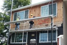 Two men work on scaffolding at a construction site