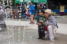 Woman and boy watch fountain in spray park