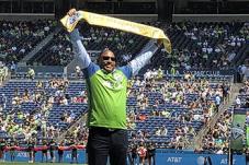 SHA Executive Andrew Lofton holds up Golden Scarf presented by Seattle Sounders FC