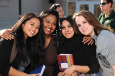 Teen girls standing together holding books