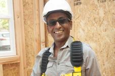 Man in hard hat and construction gear standing in front of wood frame