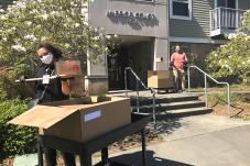 SHA staff members deliver packaged meals to residential building