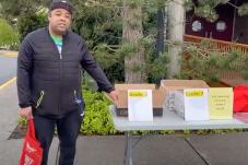 Ty Edwards by table with school packets at pick-up site