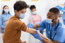 Health care worker vaccinates young man