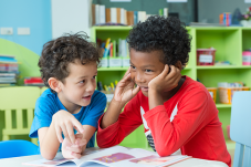 Two small boys sitting together and talking