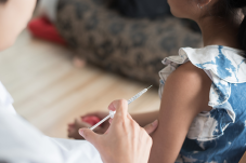 Small girl receiving injection in her arm