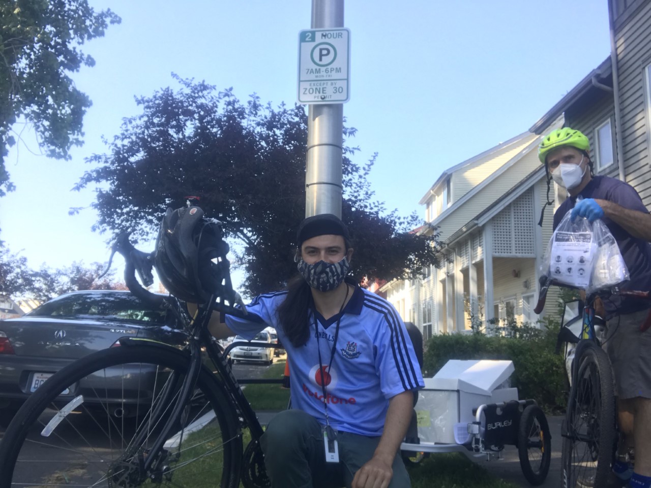 Two SHA staff members deliver face coverings to residential building