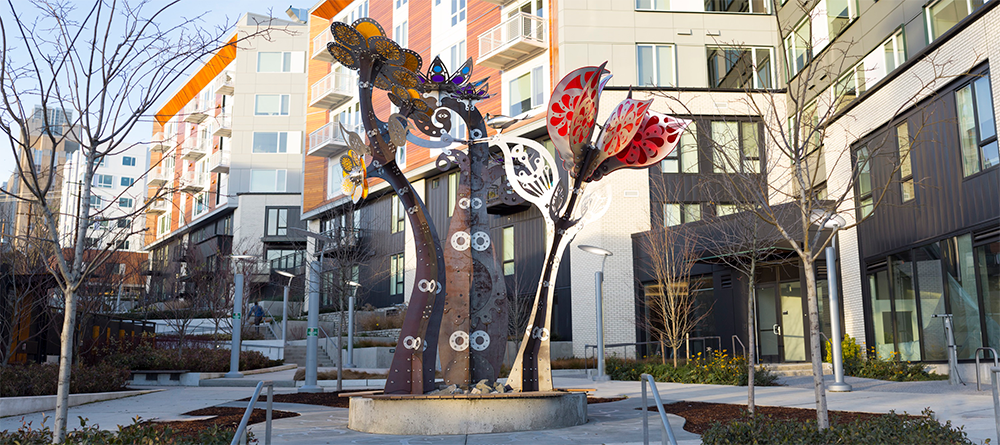 Yesler Blossoms sculpture with apartment buildings in the background
